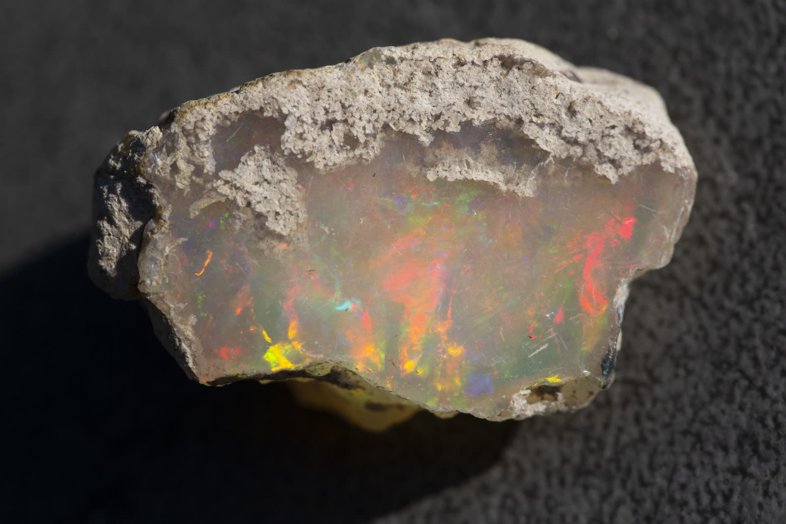 Full-spectrum Ethiopian Welo opal rough — the raw material before any cutting begins.